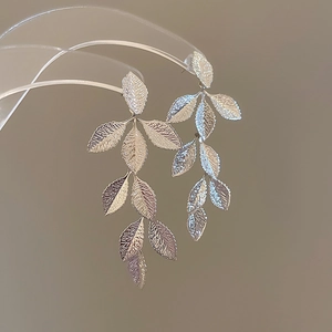 Detailed view of silver leaf tassel earrings with textured metallic finish and elegant drop
