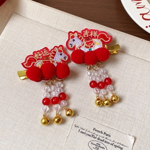 Détail de pinces à cheveux chinoises rouges festives avec broderie de cheval et glands