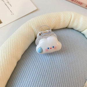 Gros plan d'une pince à cheveux nuage blanc avec gouttes bleues et ressort métallique