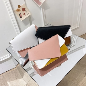 Three elegant color-block envelope crossbody bags with PU leather texture on a mirrored surface