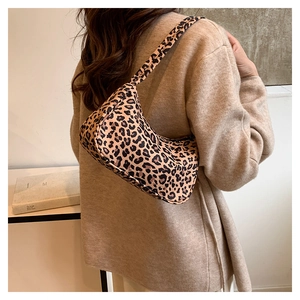 Sac bandoulière tendance à motif léopard porté par un mannequin dans un cadre épuré