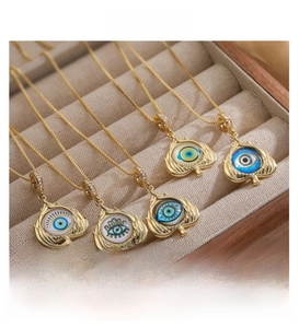 Detailed view of five golden copper Evil Eye pendants with blue eye inlay on jewelry box