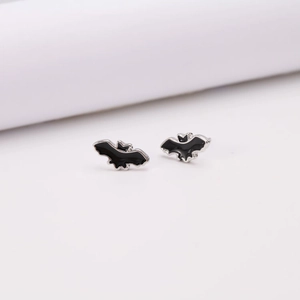 Dettaglio di orecchini a pipistrello in smalto nero con bordo argento