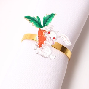 Detail of white rabbit napkin ring with orange carrot and golden metal band for dining decor