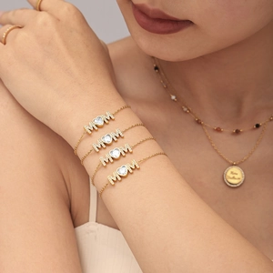 Gold-plated MOM bracelet with heart-shaped zircon shown on a model's wrist