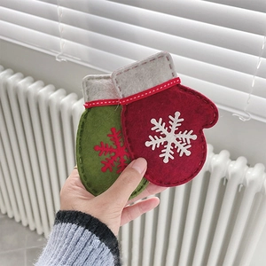 Detail of handmade felt Christmas glove ornaments held by hand with snowflake embroidery