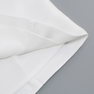 Detail shot of white satin fabric edge with premium stitching and soft glossy texture