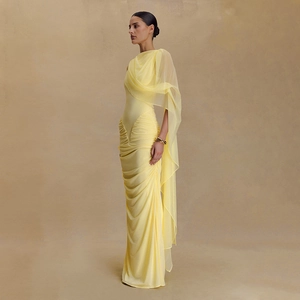 Detail of elegant yellow bodycon dress with sheer mesh cape and stylish ruched fabric