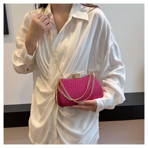 Detail of pink sequin evening clutch bag with gold chain strap on model's shoulder