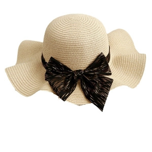 Women's woven straw sun hat with large wavy brim and elegant black bow decoration