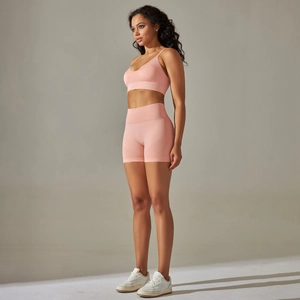 Detailed side view of pink seamless high-stretch yoga bra and biker shorts set