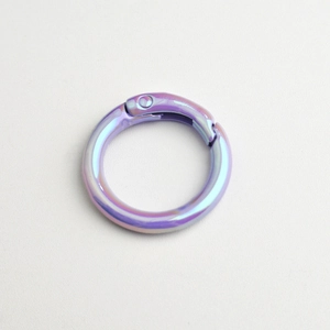 Detailed close-up of a round metal spring buckle with a vibrant rainbow plating finish