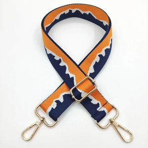 Macro detail of adjustable woven bag strap with orange and blue geometric pattern