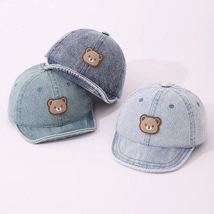 Detailed set of three soft-brim denim baby baseball caps in varied blue washes with bear patch