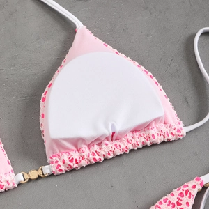 Detailed macro view of pink lace bikini top with removable pad and gold ring connector