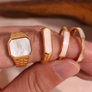 Set of four gold-plated stainless steel rings with white shell inlays and small diamonds