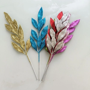 Glittery artificial Christmas tree branch ornaments in gold blue red and silver colors