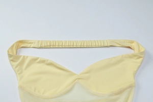 Detail of the elastic smocking and stitching on the yellow mesh off-shoulder dress