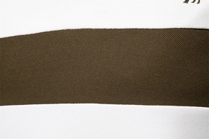 Macro shot of striped piqué cotton fabric showing texture in white and dark brown