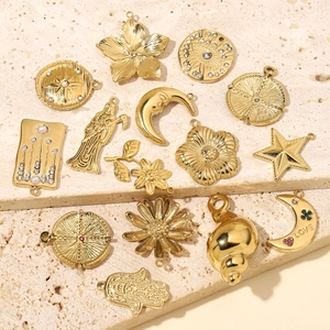Collection of gold stainless steel pendants with moon, star, and shell motifs on stone