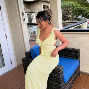 Detail of the ruffle neckline and backless tie-up design on a yellow summer maxi dress