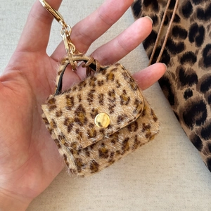 Close-up of leopard print faux fur mini bag pendant with luxury gold lobster clasp detail