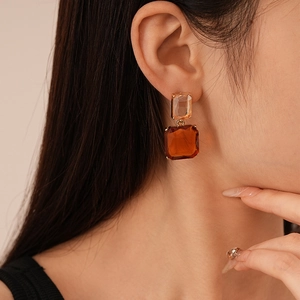 Détail de boucles d'oreilles vintage avec cristaux ambre et champagne sur mannequin