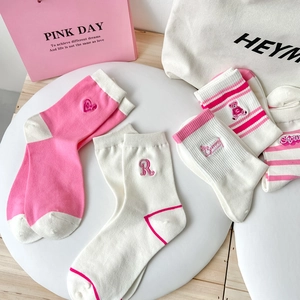 Detailed close-up of pink striped crew socks with cute bear embroidery and heart patterns