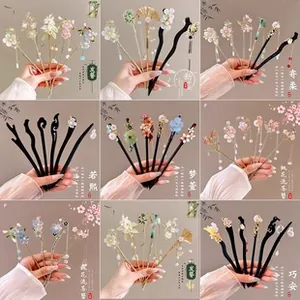 Detail view of retro Chinese hair sticks featuring resin flowers and long metal tassels