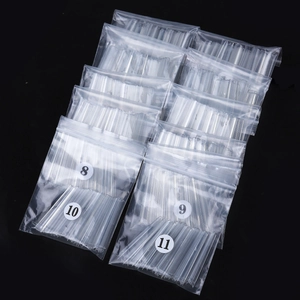Uñas postizas XXL transparentes en bolsas tallas 8 a 11 sobre fondo negro liso