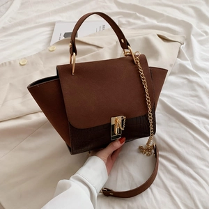 Detail of vintage crossbody bag with brown suede and crocodile texture stitching