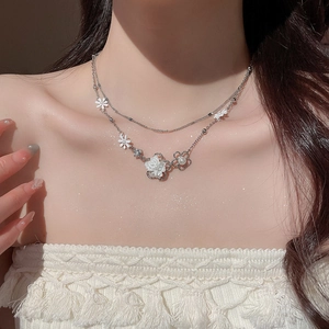 Close-up of double-layer silver flower necklace with pearls and tassels on model