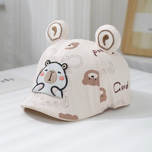 Detail of baby beige bear cap featuring 3D ears and cartoon animal patch on cotton fabric