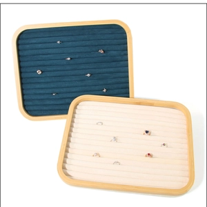 Detail of bamboo jewelry tray with velvet ring slots in cream and dark teal colors