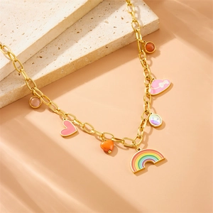 Collier en chaîne dorée avec breloques cœur et arc-en-ciel colorées sur pierre