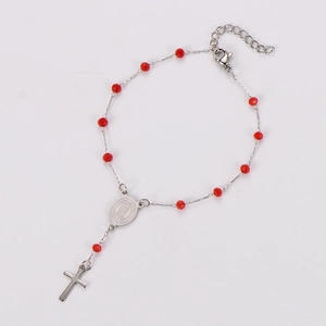 Detail of red beaded rosary bracelet with silver crucifix and holy medal pendant