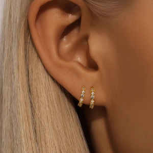 Detail of S925 silver hoop earring with cubic zirconia and drop chain on ear