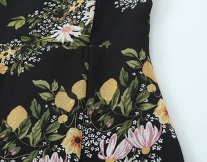 Detailansicht von schwarzem Chiffonstoff mit Zitronen- und Gänseblümchen-Blumenmuster