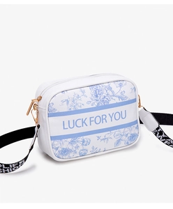 Detail of blue floral Toile de Jouy print and wide strap on white crossbody bag