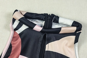 Detailed macro view of high neck and back zipper on geometric print slim jumpsuit