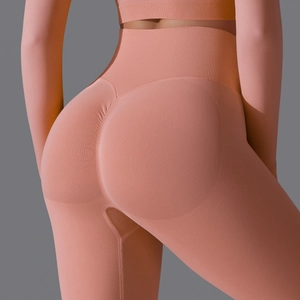 Detail of high waist seamless peach yoga pants with scrunch butt shaping in pink orange
