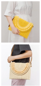 Detail of hand-woven straw envelope clutch with tassel trim and detachable leather strap