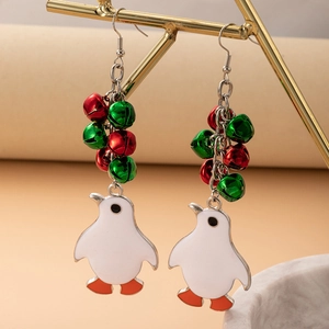 Detail shot of Christmas penguin earrings with festive red and green bells on a gold stand