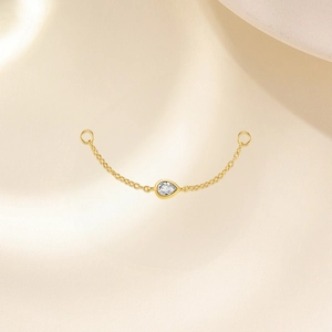 Détail d'un accessoire en argent S925 doré avec zircon marquise et fine chaîne élégante