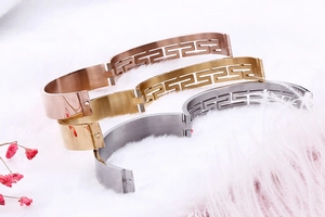 Macro detail of tricolor gold silver and rose gold bangles with Greca pattern