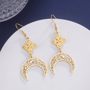Detailed macro of golden hook earrings featuring hollow crescent moon and Celtic knot designs