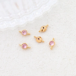 Macro detail of gold-plated jewelry connectors with pink cubic zirconia for DIY jewelry