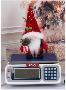 Detailed view of a 69g sequined Christmas gnome gnome on a scale for weight display
