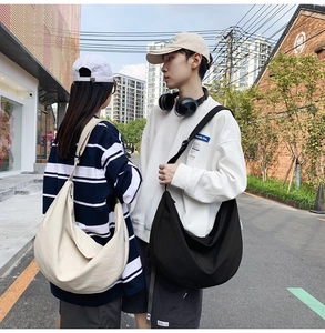Close-up of large crescent oxford crossbody bags in beige and black on models