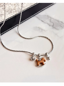 Détail du pendentif cheval à bascule en bois avec cloche argentée et cœur sur chaîne